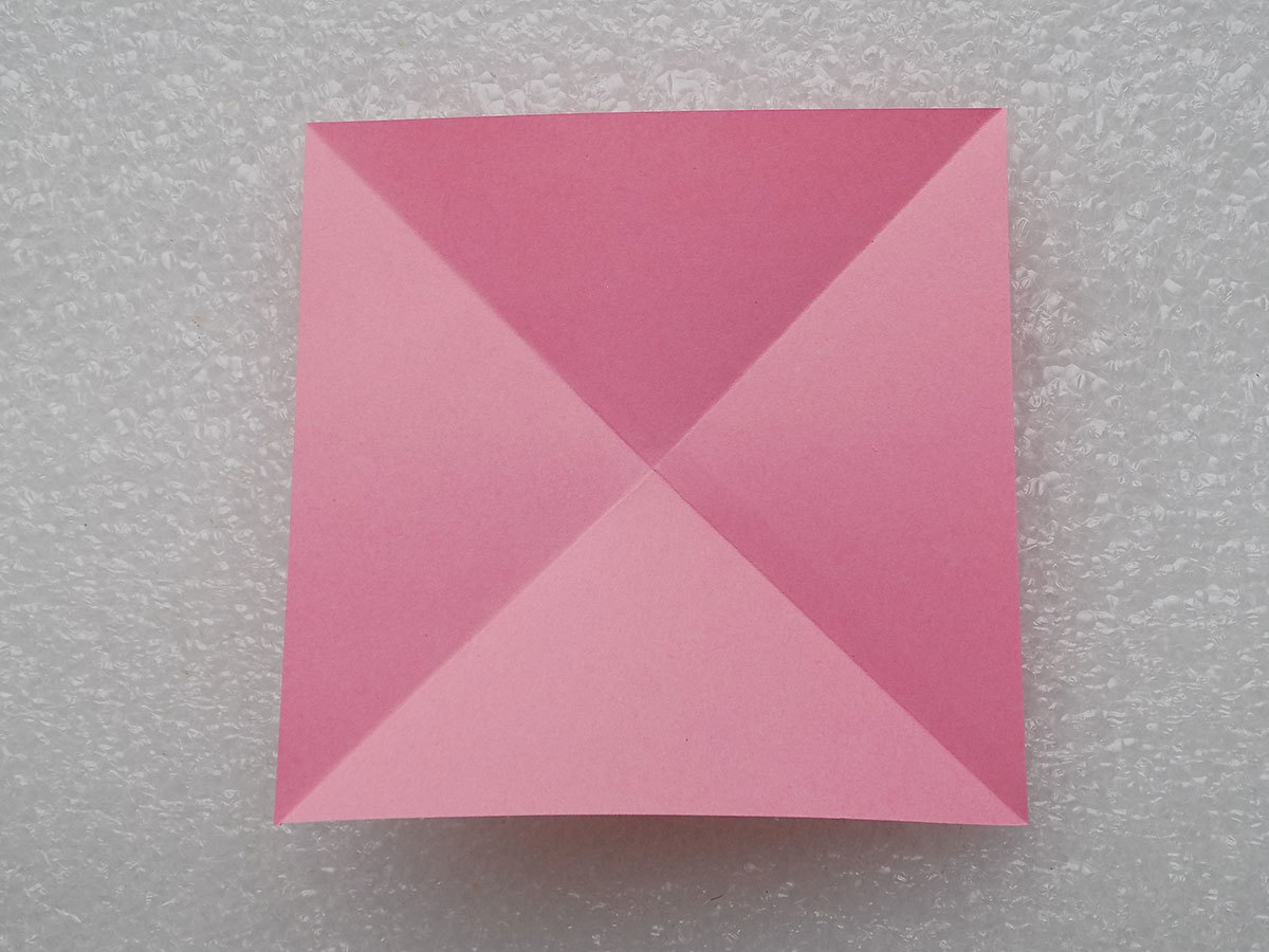 Лист бумаги для поделки-собаки складывается по диагонали дважды