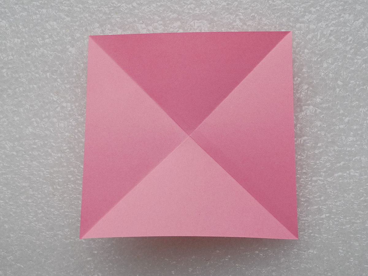 Ein Blatt Papier für Handwerk wird zweimal diagonal gefaltet