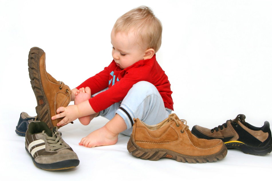 Otrok poskuša čevlje za odrasle