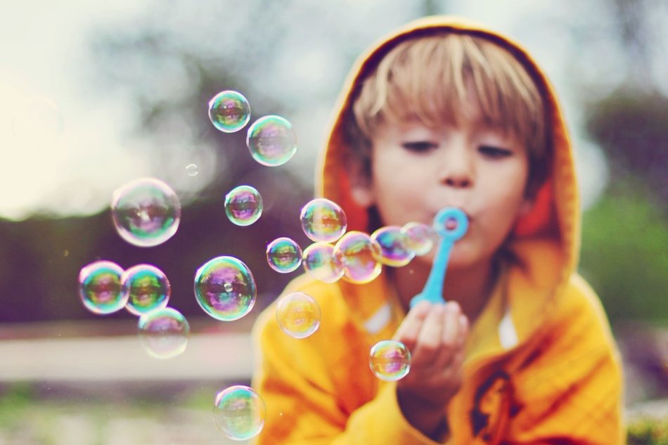Ребенок выдувает мыльные пузыри из домашнего раствора без глицерина