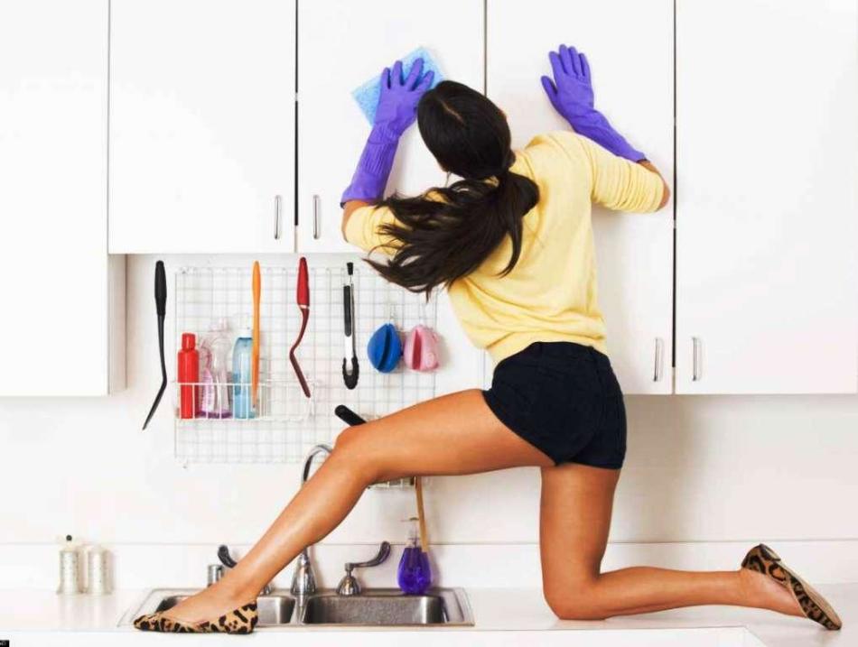 A lány a szekrényeket mosja a konyhában a légy hölgy rendszere szerint