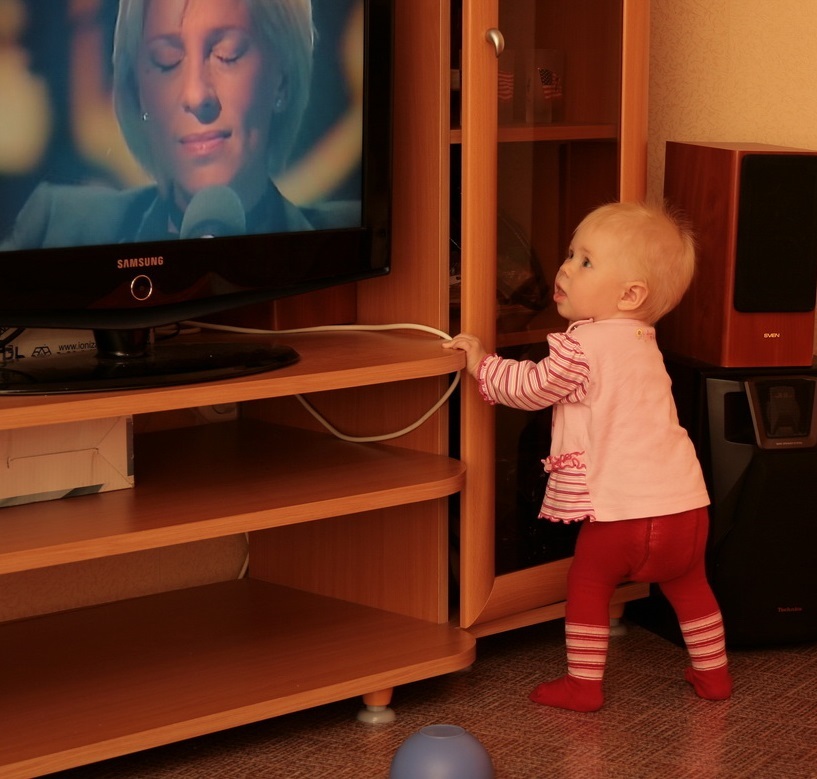 Малыш близко стоит возле телевизора