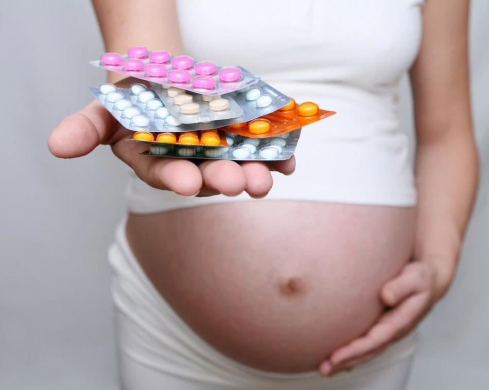 Egy terhes lány maroknyi antidepresszánsot tart a kezén hólyagokban