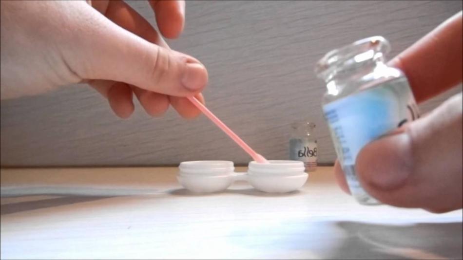 A person washes a container for storing contact lenses with saline