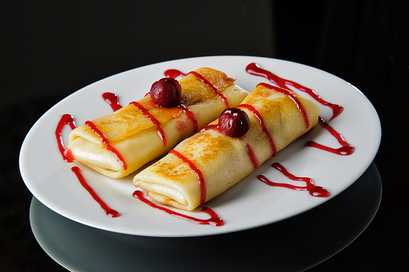 Pancakes with cottage cheese and cherry filling.
