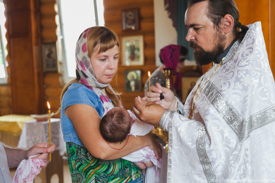 Seorang wanita di baptisan seorang anak, imam itu membaca doa permisif atas dirinya