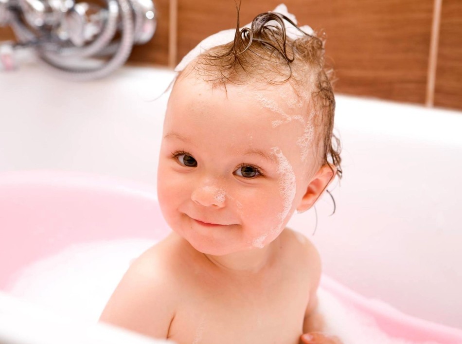 Bayi di kamar mandi dengan rambut basah sebelum menyisir kerak