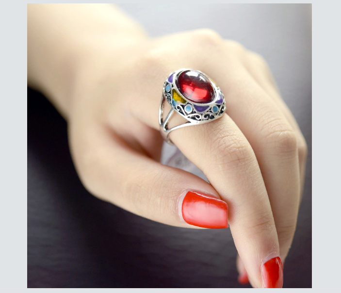 Перстень с красным рубином на указательном пальце руки у девушки