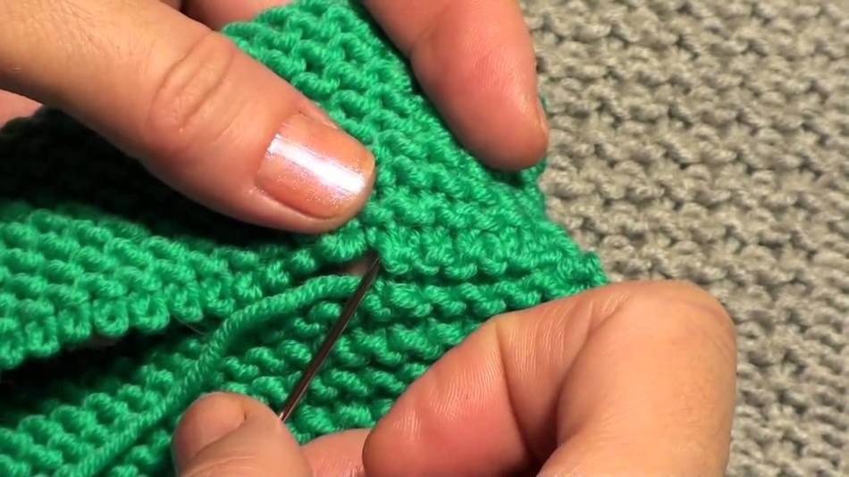 Sewing knitted parts with a needle