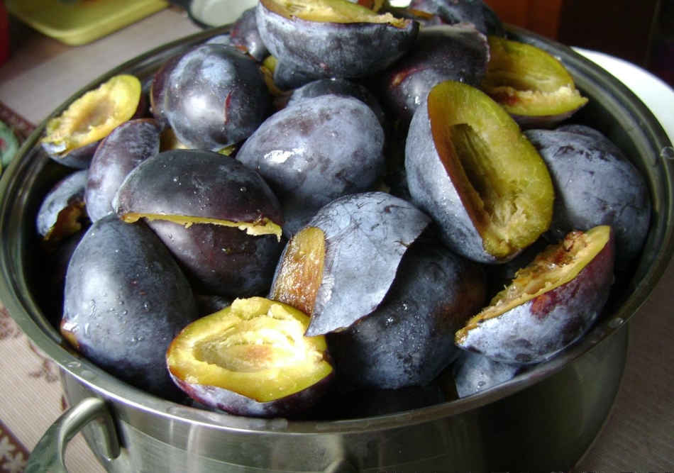 Plums without bones are folded into a pan before cooking sauce