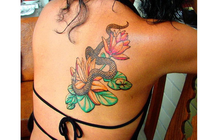 Fashionable tattoo on a shoulder blade with a snake