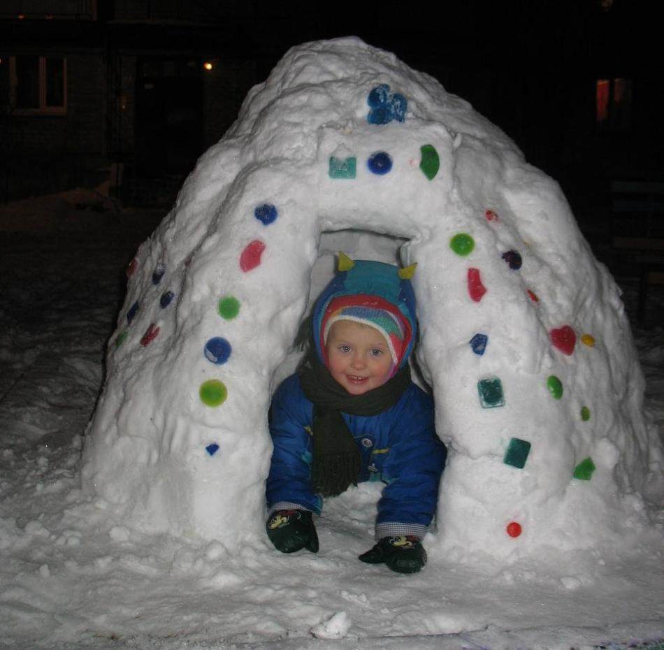 Ett dekorerat nålark från snön från vilken barnet kikar