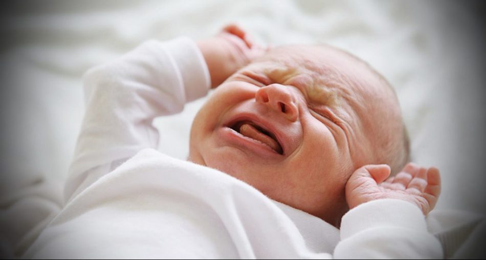 A newborn baby cries bitterly without tears