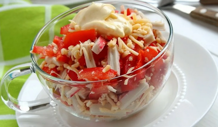 Insalata con bastoncini di granchio con pomodori, formaggio e pepe