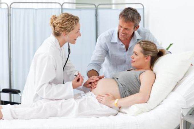 Egy férfi szülésben - koherens egy nő és az orvosi személyzet között.