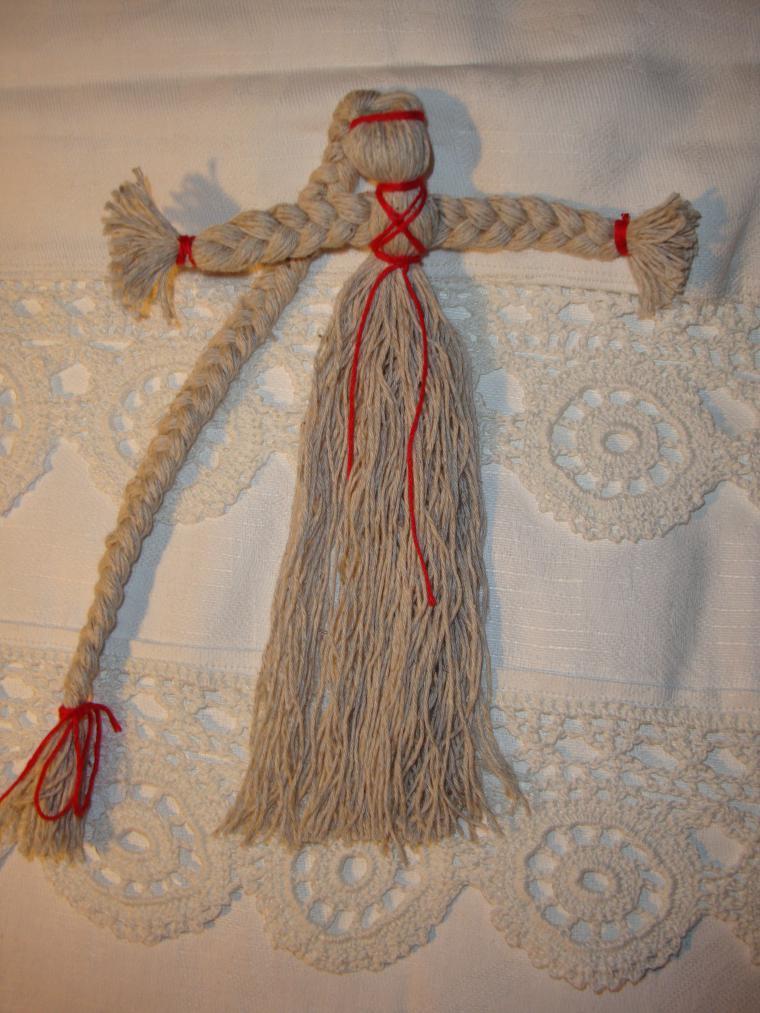 Distinctive features of the doll -worker for health - a large braid and a cross made of red threads