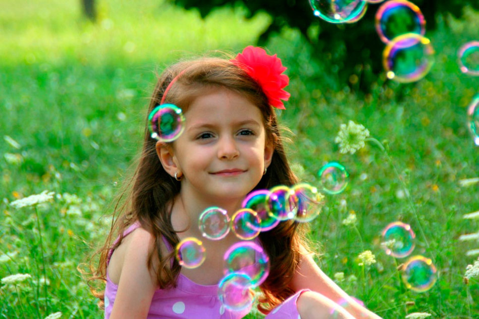 Девочка в окружении мыльных пузырей, изготовленных в домашних условиях
