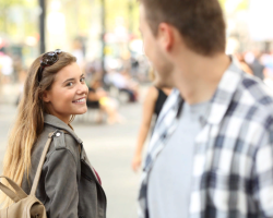 Mengapa seorang pria tersenyum pada gadis itu saat bertemu: tanda -tanda apa, apa artinya ini dalam bahasa gerakan?