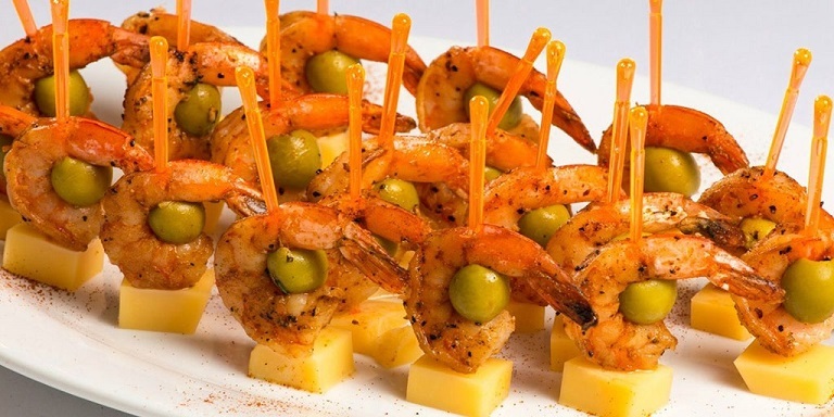 Canapes avec des crevettes et des olives au tableau du Nouvel An 2023