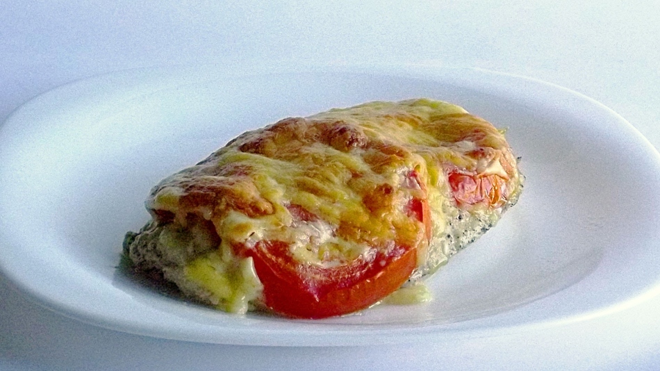Steak from a turkey fillet in the oven with tomatoes and cheese