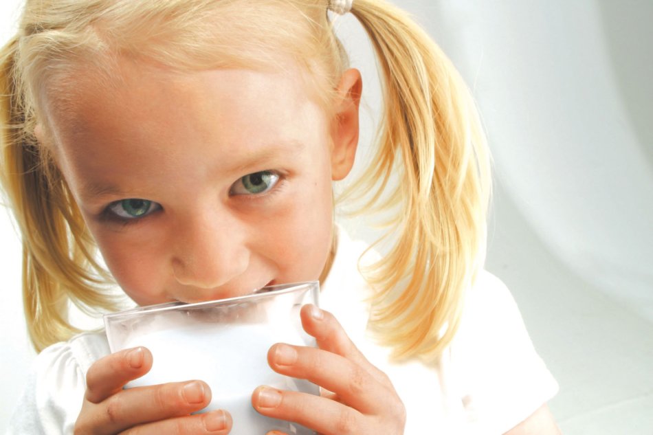 Ragazza con un bicchiere di latte di capra