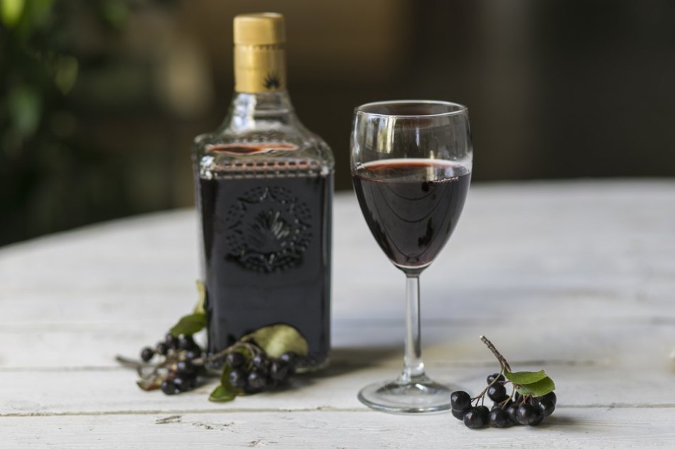 Bouteille, verre de vin à la maison et grappes de cassis