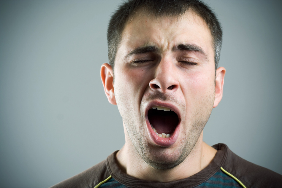 A man yawns in a gym