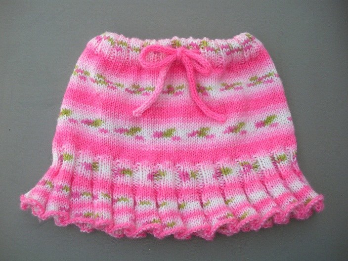 Jupe chaude des enfants avec des aiguilles à tricotage