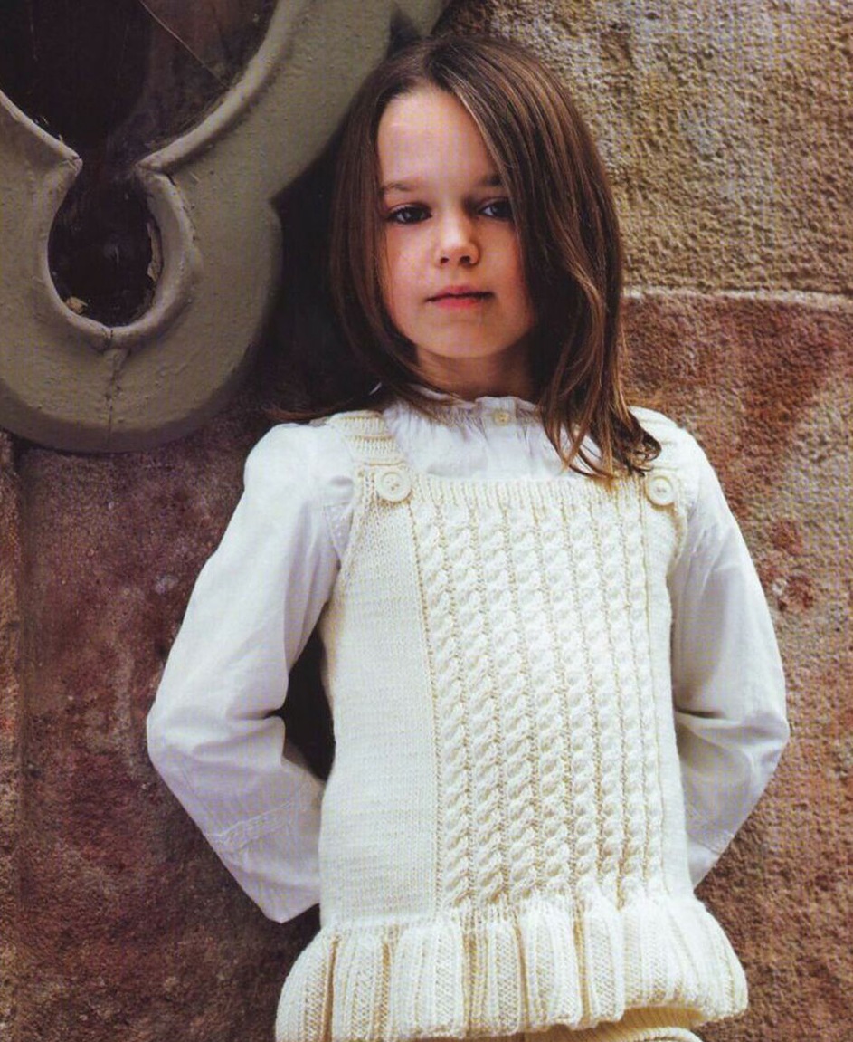 Beau gilet pour une fille aux aiguilles à tricot blanc