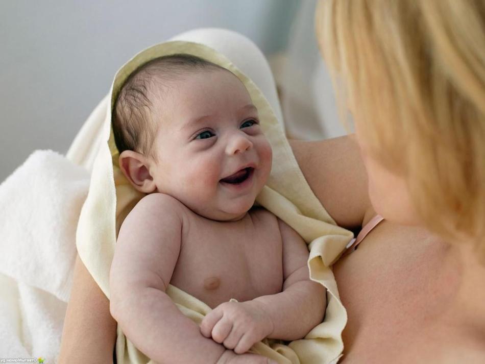 Maman essuie le bébé avec une serviette après avoir baigné et peigné les croûtes